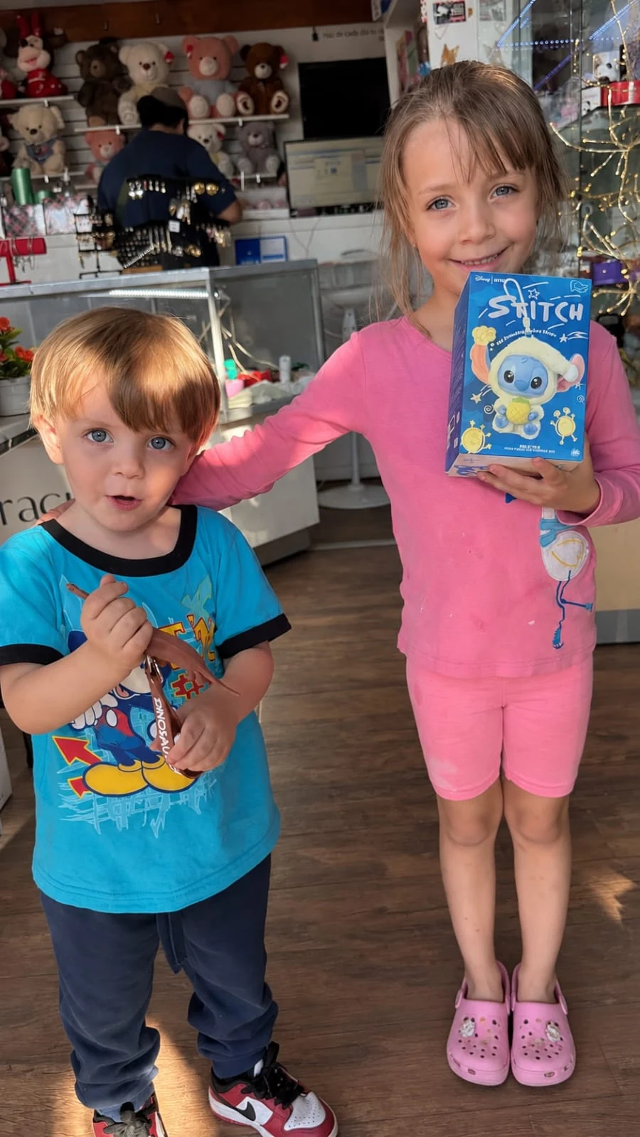 Niños felices mostrando un regalo especial en tienda